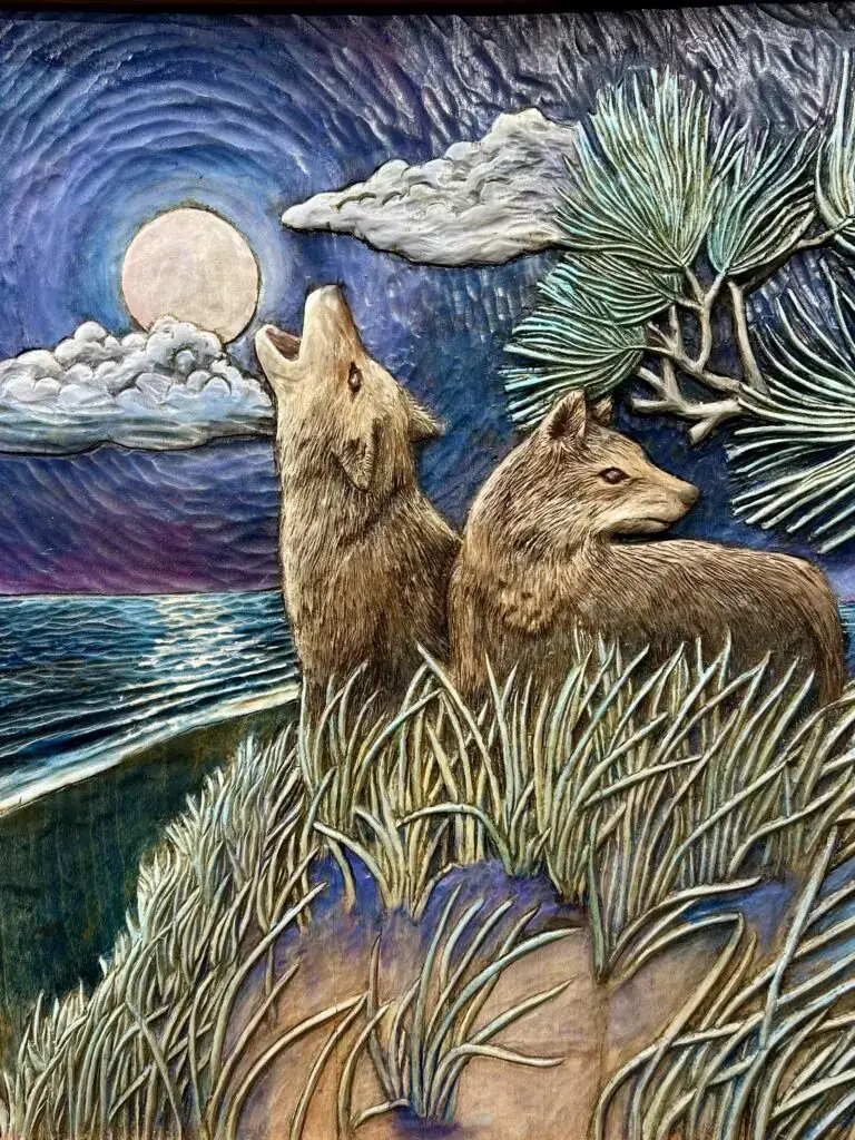 Gary Cota's hand-carved, painted wood relief of two coyotes on the Cape Cod dunes, one howling to the moon and the other on edge looking