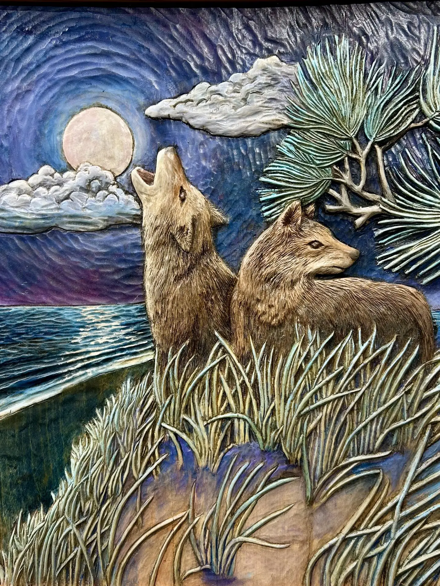 Gary Cota's hand-carved, painted wood relief of two coyotes on the Cape Cod dunes, one howling to the moon and the other on edge looking