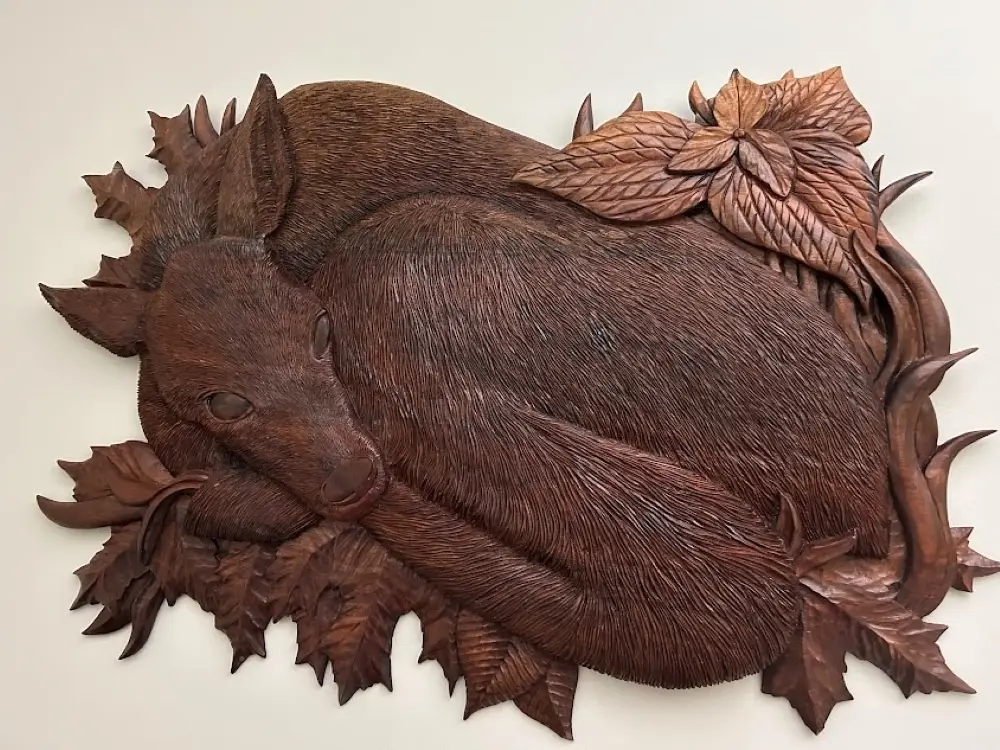 Gary Cota's hand-carved, wood relief of a fawn hiding in the grass. Each individual hair is carved