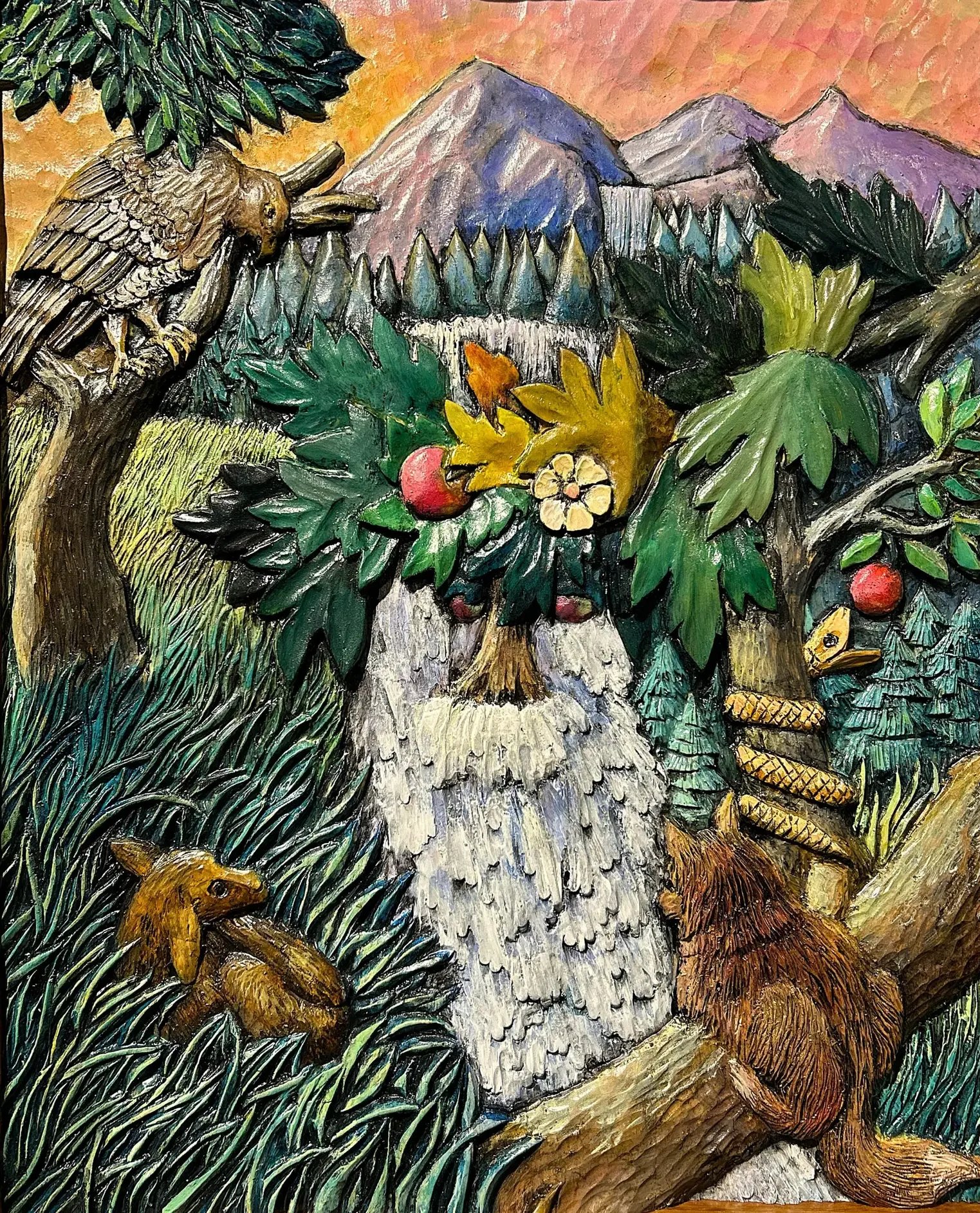 Award-winning wood carving by Gary Cota featuring the profile of a wise old man formed by trees, leaves, and cascading water. An owl, fox, squirrel, and snake are hidden throughout the richly detailed forest scene, with mountains and a waterfall in the background, inviting viewers to discover new elements with each look.
