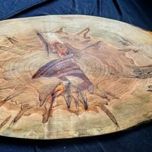 Spalted maple charcuterie board with an inlaid dolphin design.