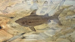 Spalted maple charcuterie board with a hand-carved and inlaid shark.